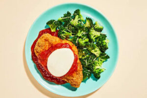 Plated Freshly low-carb meal breaded chicken breast marinara sauce and broccoli